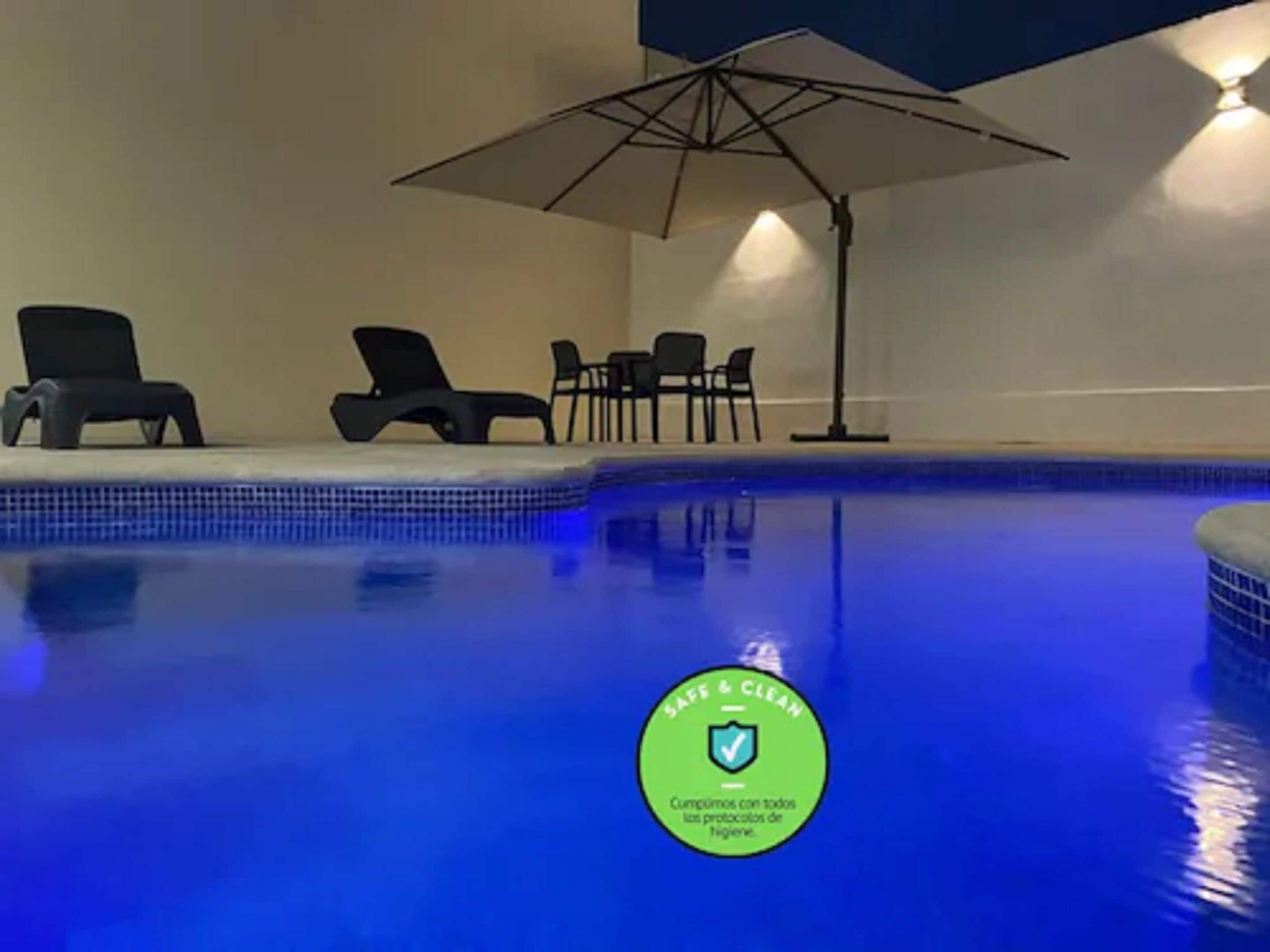 Alberca al aire libre, sombrillas en la alberca y camastros 