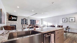 Una cocina moderna con una isla grande, electrodomésticos de acero inoxidable y un salpicadero de piedra.