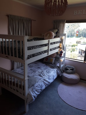 A bunk bed room with a window view, a hanging light fixture, and a small rug. - Great View, Close to The Mission (Taradale)