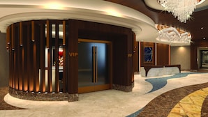 A VIP reception area with a modern design, featuring a curved reception desk, a chandelier, and a marble floor.