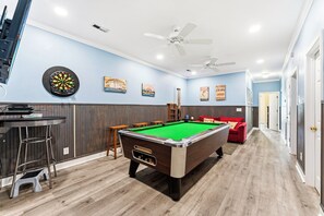 A room with a pool table, dartboard, and bar area. - Atlantis Villas 104 -Renovated 6 BR-Game Room-Pool (NORTH MYRTLE BEACH)