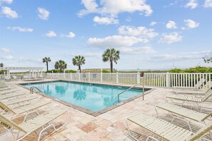 A pool area with lounge chairs and a white fence. - Atlantis Villas 104 -Renovated 6 BR-Game Room-Pool (NORTH MYRTLE BEACH)