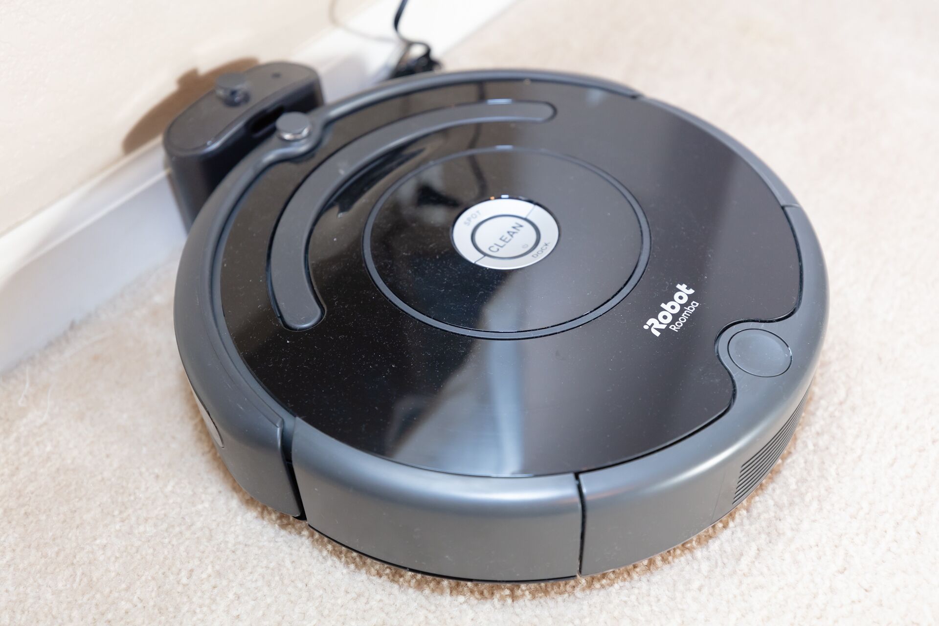 A black robotic vacuum cleaner with a 'CLEAN' button and 'Robot Roomba' label.