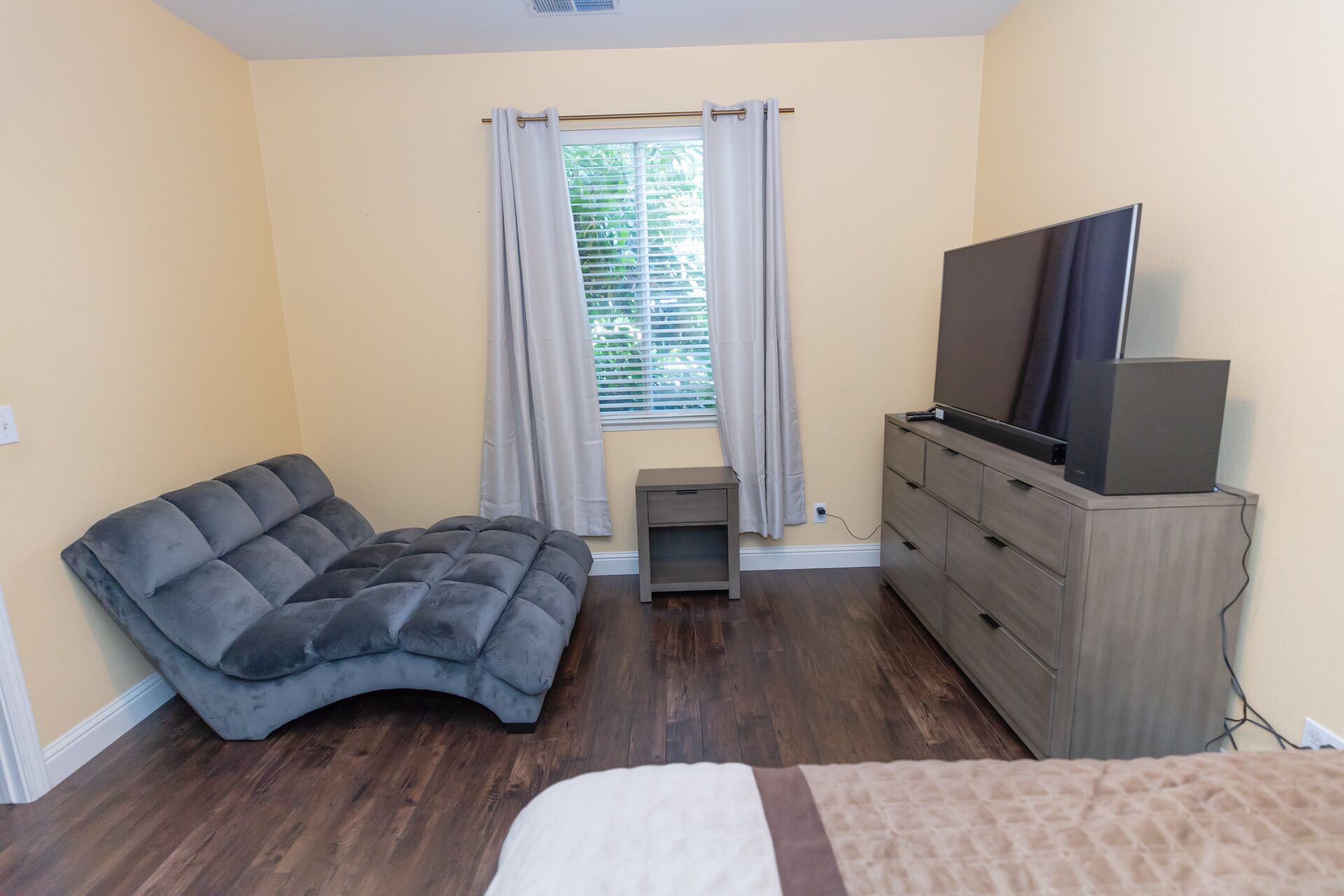 Ein Schlafzimmer mit einem Bett, einem Sofa, einem Fernseher und einer Kommode.