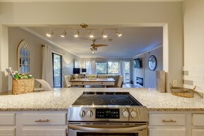 Enjoy cooking in this well-equipped kitchen with a central island, stainless steel stove, and oven, plus a dining area with a table and chairs.