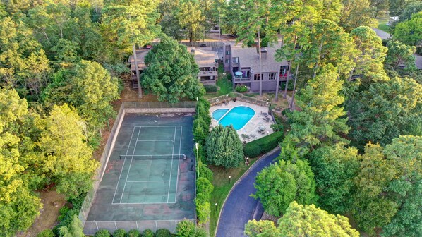 Enjoy a secluded retreat with a tennis court and swimming pool surrounded by lush greenery.