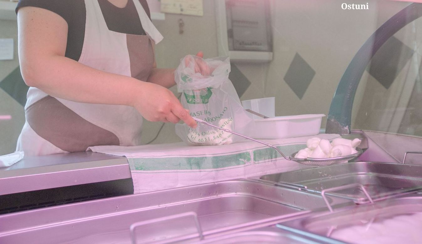 A person preparing food in a kitchen with a focus on dairy products.