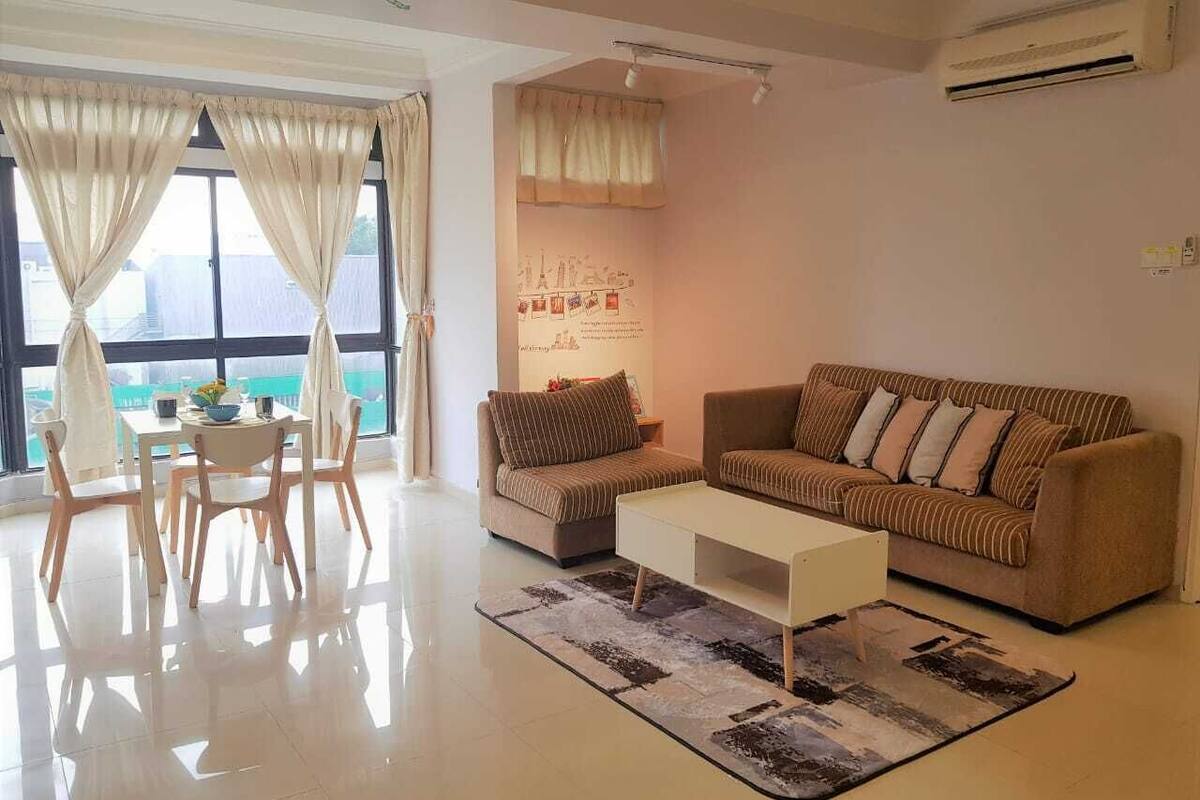 A living room with a sofa, armchairs, a coffee table, and a dining area with chairs and a table.