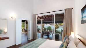 A bedroom with a large bed, a view of the balcony, and a door leading to the outdoor area. - Villa Mer Vue (Madampagama)