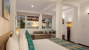 A bedroom with a bed, a sofa, a window with a view of the sea, and a painting on the wall. - Villa Mer Vue (Madampagama)