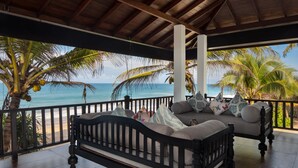 A wooden deck with a bed and a view of the ocean. - Villa Mer Vue (Madampagama)