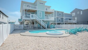A multi-story residential building with a pool and outdoor seating.