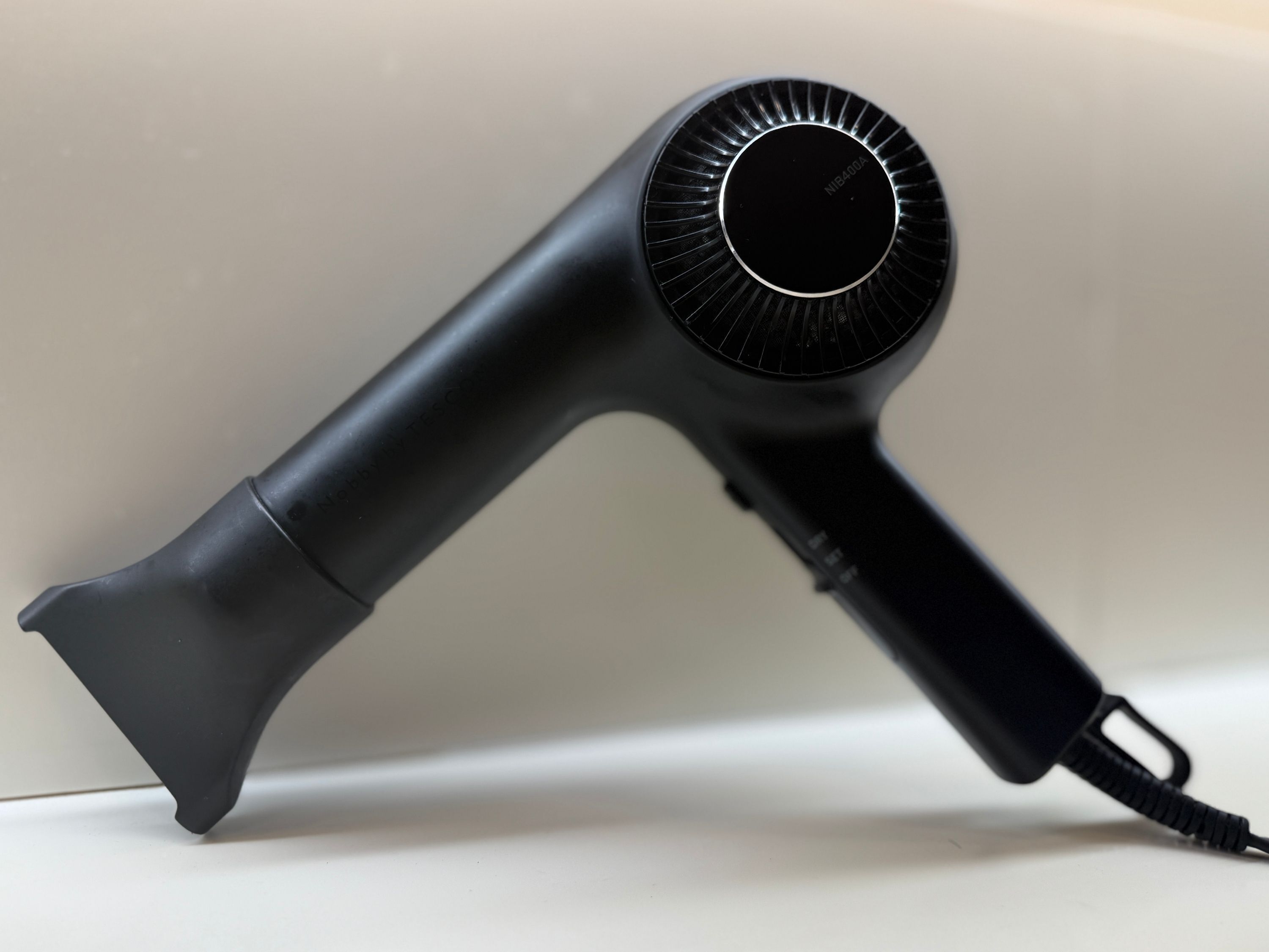 A black hair dryer with a cord.