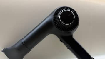 A black hair dryer with a cord.