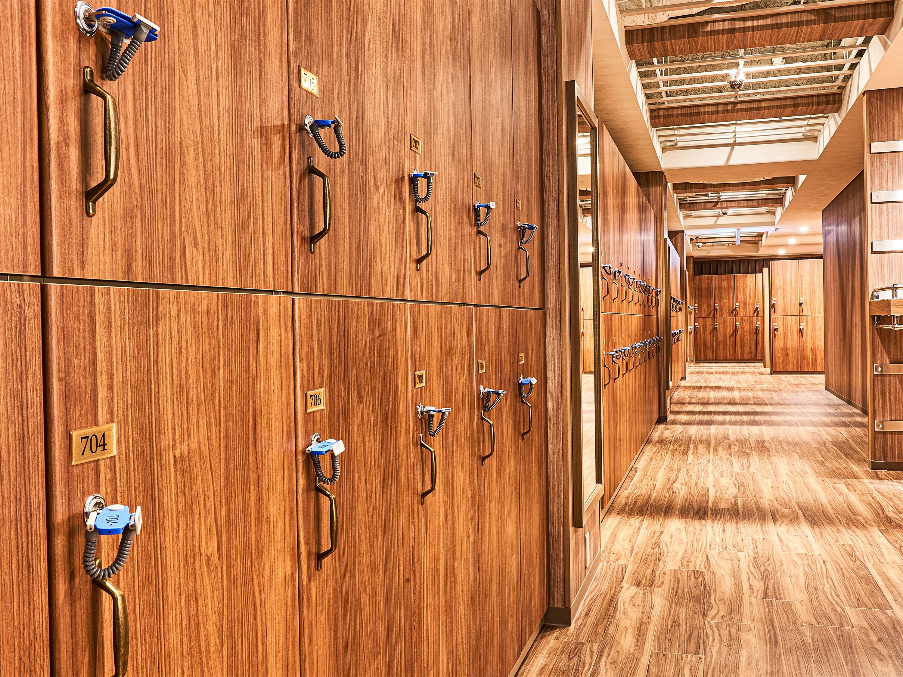 A hotel corridor with wooden lockers and a wooden floor.