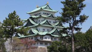 A traditional Japanese castle with multiple tiers and green roofs, surrounded by trees. -  Anshin oyado Woman & Man Nagoya (Nagoya)