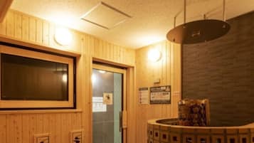 A wooden interior with a reception desk, a large window, and a wall-mounted light fixture.