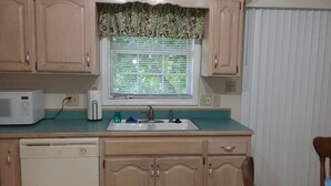 A kitchen with wooden cabinets, a microwave, a toaster, and a sink. - The Southwest Place 2203 (Ozark)