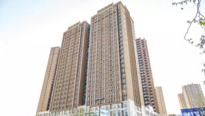 A high-rise building with multiple floors, featuring a uniform facade and numerous windows.