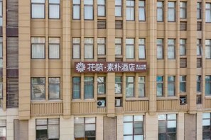 A building facade with multiple windows and a sign indicating a hotel.