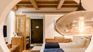 A circular view of a hotel room with a bed, a desk, a chair, and a wooden partition.