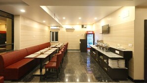 Um restaurante com um balcão comprido, cabines e um refrigerador de Coca-Cola.