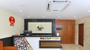 Uma mesa de recepção com logotipo, computador e telefone.