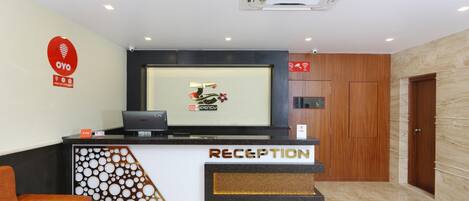 Un mostrador de recepción con un logotipo, una computadora y un teléfono.