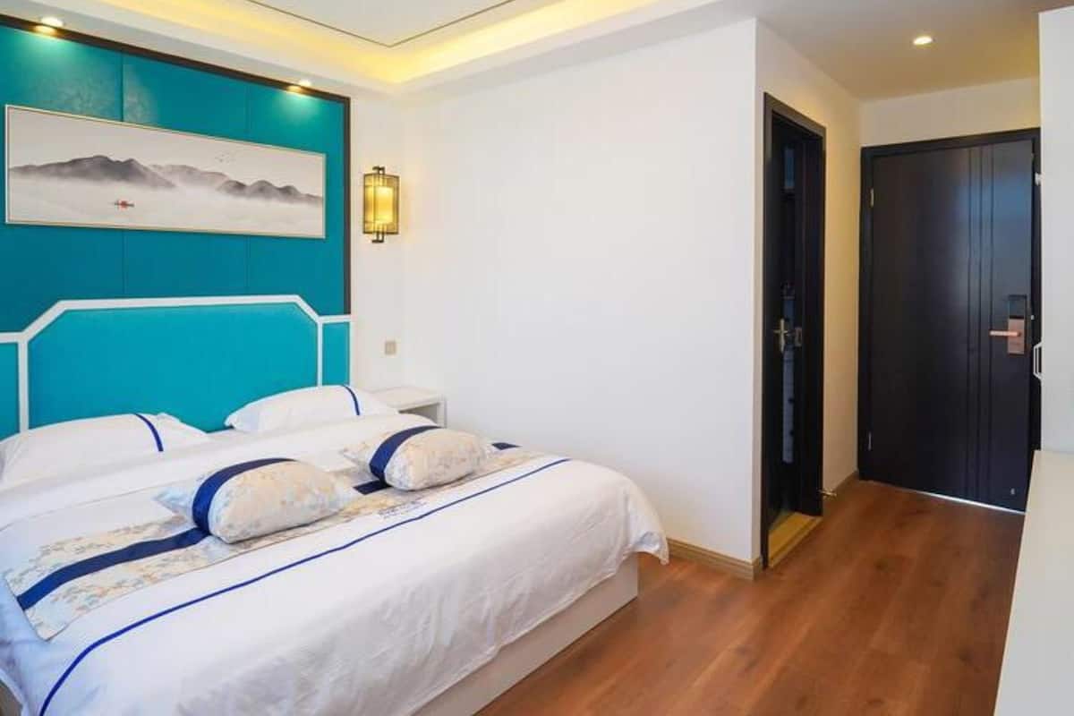 Un dormitorio moderno con una cama, una lámpara de pared y una puerta.