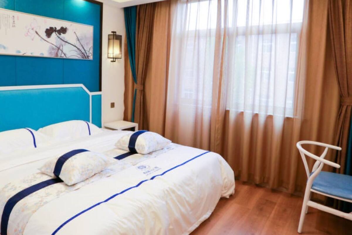 Una habitación de hotel con una cama grande, un escritorio y una silla.