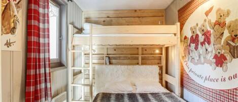 A bunk bed room with a red and white checkered curtain, a fluffy grey blanket, and a wall mural of teddy bears.