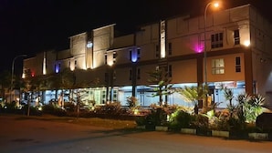 A multi-story hotel with illuminated signage and a well-lit facade. - Ants Hotel (Kangar)