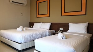 Two twin beds with white linens, a wall-mounted air conditioner, and two framed pictures on the wall. - Ants Hotel (Kangar)