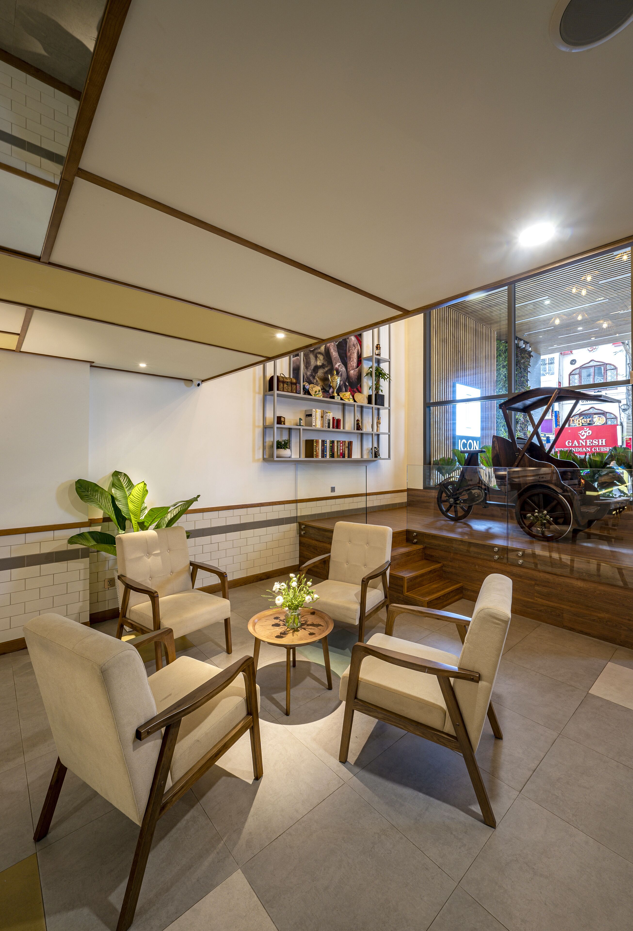 A lobby with a seating area, a bookshelf, and a vintage car display.