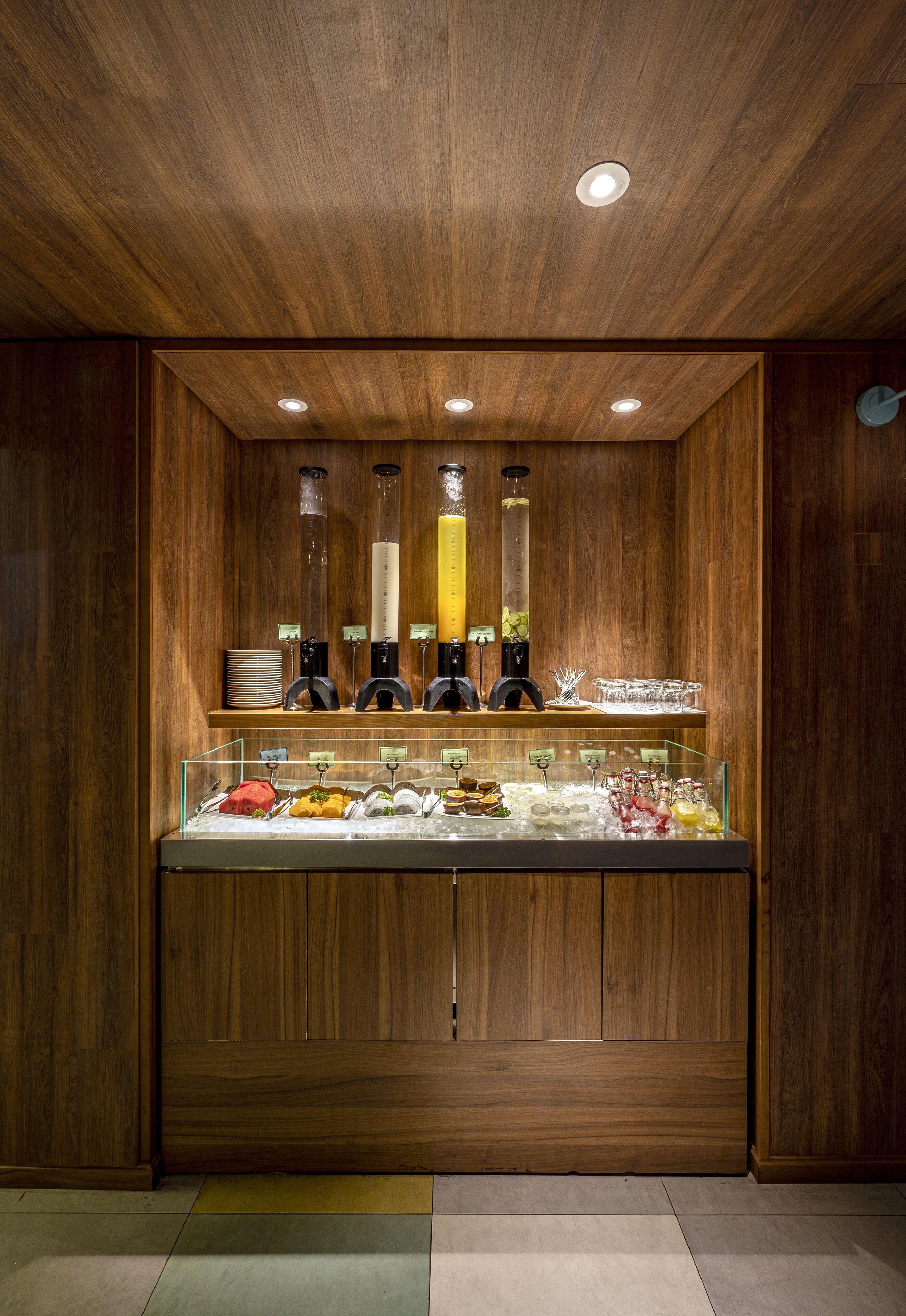 Un'area buffet con pannelli in legno, una vetrina per alimenti e illuminazione a soffitto.