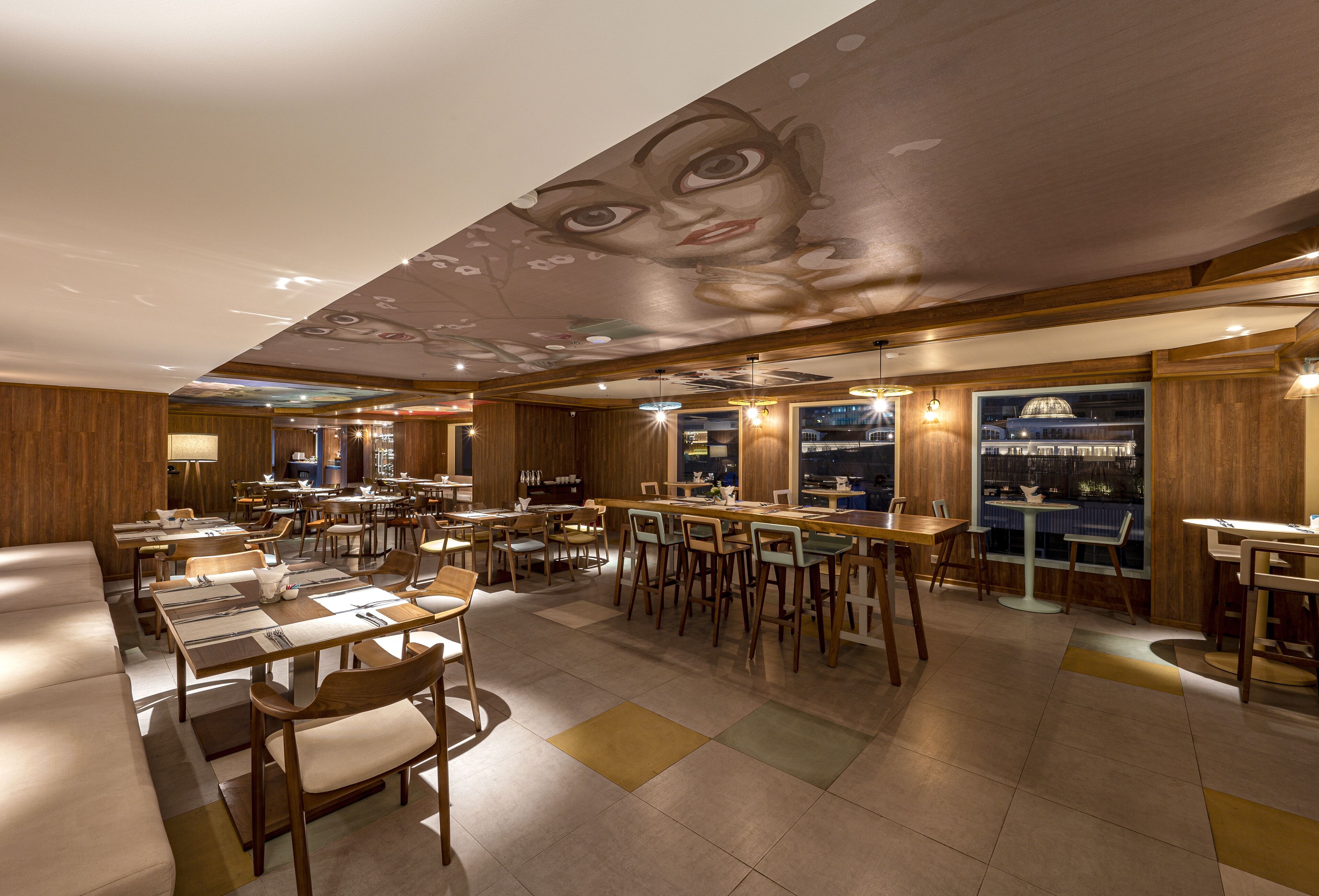A restaurant with wooden walls, multiple dining tables, and chairs.