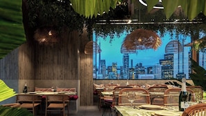 Un restaurante con vista al horizonte de la ciudad, paredes de madera y muebles de mimbre.