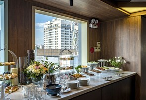 Un bufé de desayuno con diversas opciones de comida y una amplia vista panorámica de la ciudad.