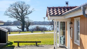 Un edificio de madera con tejado de baldosas que da a un lago.