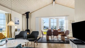 Una sala de estar acogedora con chimenea, un comedor con vistas y una cocina con estufa.