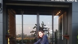 A person sitting on a bicycle in front of a café named "JAIDEE CAFÉ". - Jaidee Cafe & Hostel Chiangrai (Chiang Rai)