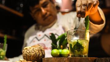 Une personne verse une boisson dans un verre, et une tranche de citron vert est posée sur le bord du verre.
