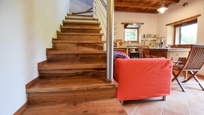 A wooden staircase leading to a kitchen area with a dining table and chairs.