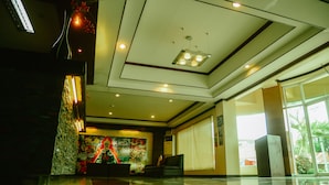 A lobby with a modern ceiling design, a large window, and a decorative wall.