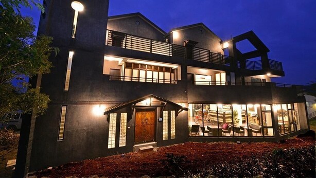 A modern two-story house with a balcony, large windows, and a well-lit entrance. - Sunlight Gallery landscape B&B (Chenggong)