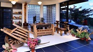 A modern interior with a wooden table and benches, a large window, and a view of the outdoors. - Sunlight Gallery landscape B&B (Chenggong)