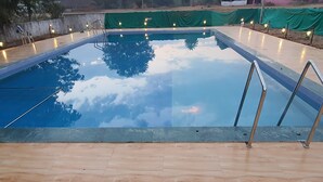 A rectangular swimming pool with a clear blue water surface, surrounded by a wooden deck.