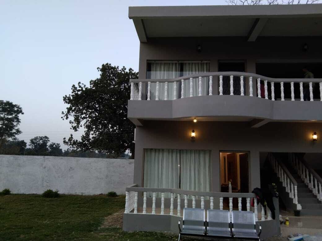 A two-story building with a balcony, a staircase, and a bench outside.
