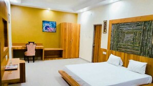 A bedroom with a bed, a desk, a chair, and a wardrobe.