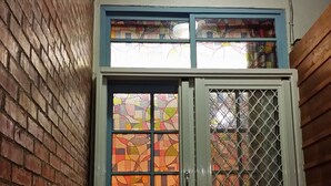 A room with a blue door, a window with stained glass, and a wicker chair. - Exotic wind sand city 86 (Taitung)